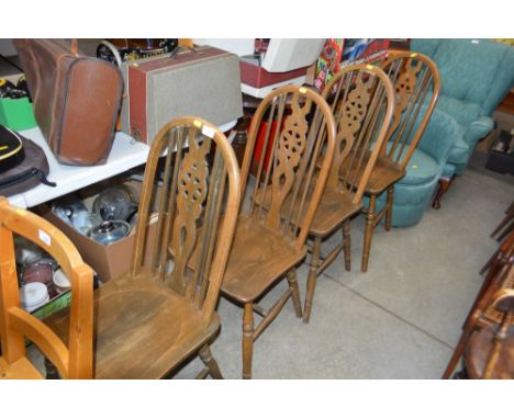 A set of four stick and wheel back dining chairs