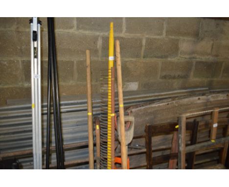 A quantity of long handled tools; walking cane bearing labels and a long handled ladle 