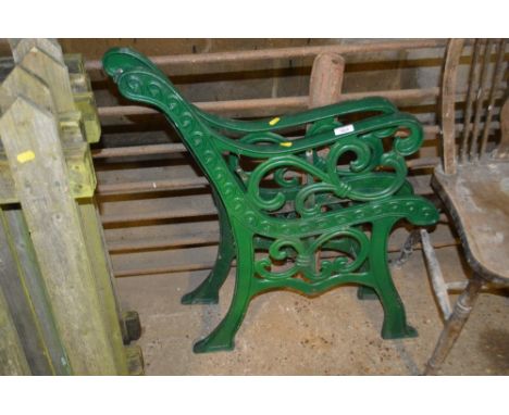 A pair of green painted bench ends 
