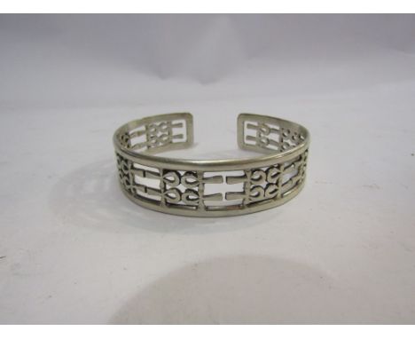 A pierced design open cuff bangle stamped 925 