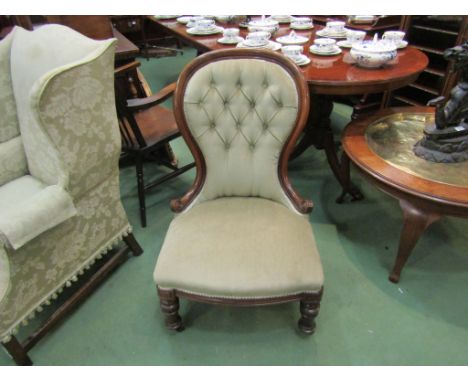 A Victorian button-back open armchair in green velour on castors