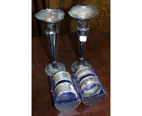 A cased pair of hallmarked silver engine turned napkin rings, Chester 1909; a pair of embossed napking rings, Birmingham 1909