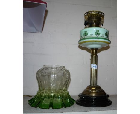 A Victorian oil lamp with brass column, green painted reservoir and green tinged folded shade, height 25"