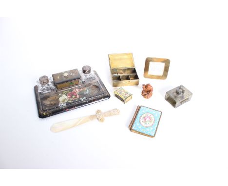 A collection of desk items, comprising a papier-mache inkstand with two ink bottles, enamel notebook, hard stone matchbox cov