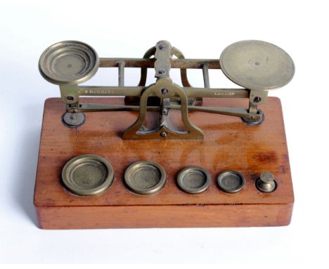 A set of brass postal scales by Sampson Mordan &amp; Co. London, on a walnut base, 16cm long 
