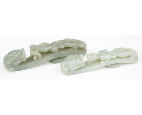 * Jade. A Chinese jade belt hook, carved as a chilong with bifad tail confronting a dragon, 11 cm long, together with a simil