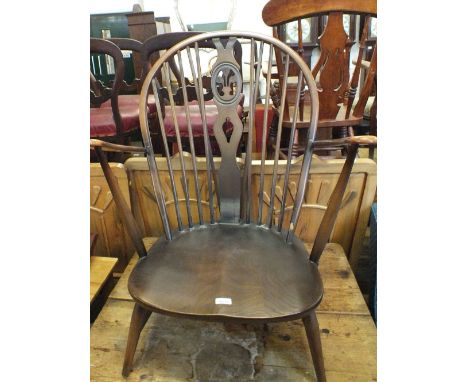 A pair of dark stained Ercol low stick back chairs