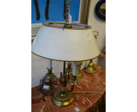 A brass three branch table lamp with toleware style shade.