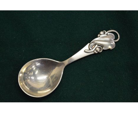 A silver caddy spoon.