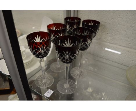 A set of six wine glasses with ruby tinted bowls.