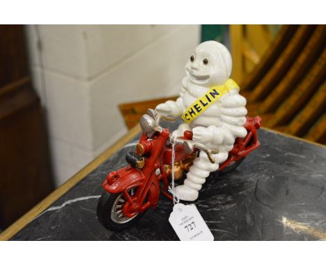 A cast iron Michelin man on a motor bike.