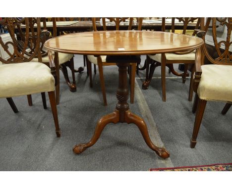 A George III mahogany circular tilt-top bird cage tripod table, the cabriole legs ending with carved claw and ball feet.