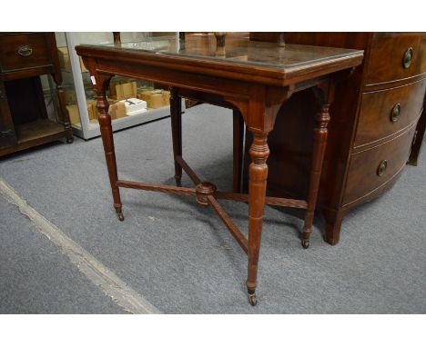A Victorian rectangular fold-over swivel top card table on turned supports.