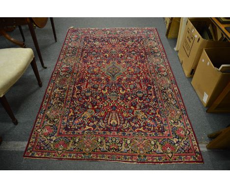 A Persian rug, red ground with floral decoration, 226cm x 142cm.