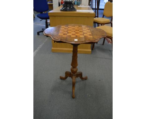 A Victorian walnut tripod drop-flap games table with drawers to each end and inlaid chess board top.