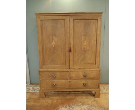 A Georgian mahogany and vase inlaid Linen Press fitted pair of cupboard doors above base fitted two short and one long drawer