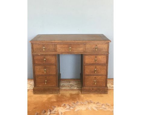 An Edwardian oak Pedestal Desk with brown leather inset writing surface above nine drawers on plinth base 3ft 7in W x 2ft 7in