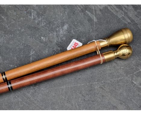 Two novelty brass mounted sectional canes, each enclosing a concealed compass and flask.
