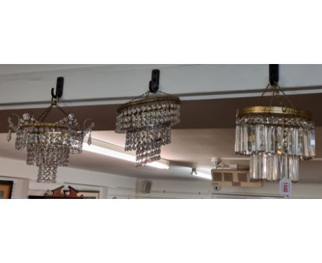 A faceted glass drop two-tier chandelier, 19cm high; together with two other faceted drop ceiling lights. (3)
