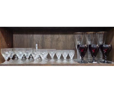 A part suite of drinking glasses; together with a set of three oversized goblets, 28.5cm high, (chip to foot rim of one); and