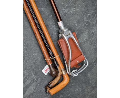 A vintage Ford shooting stick; together with three various canes. (4) 