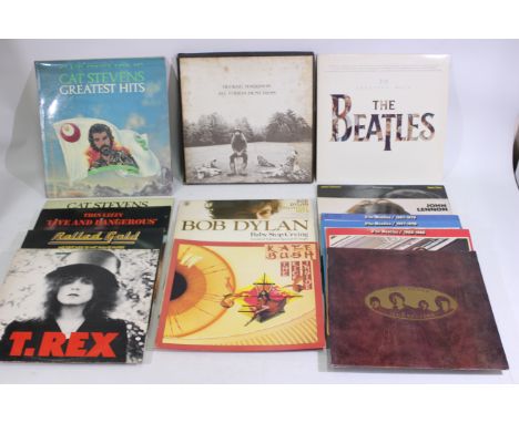 A collection of 12" vinyl records to include Bob Dylan, The Beatles, Kate Bush, The Rolling Stones, Cat Stevens, Thin Lizzy a