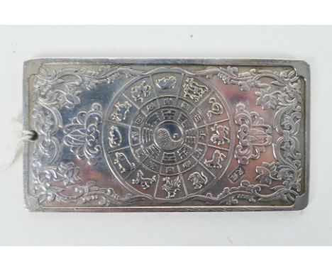 A Chinese white metal (presumed silver) ingot / plaque with depiction of a five clawed dragon to one side and zodiac amidst f