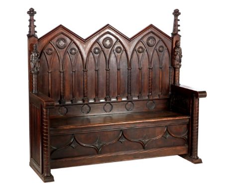Neo-Grotic oak bench with fine carving and figures of a knight and damsel, 144 cm high, 153 cm wide, 56 cm deep