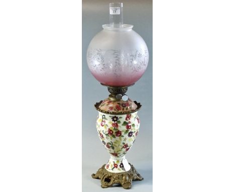 Early 20th century double oil burner lamp having frosted and etched globular shade above a ceramic  floral reservoir on cast 