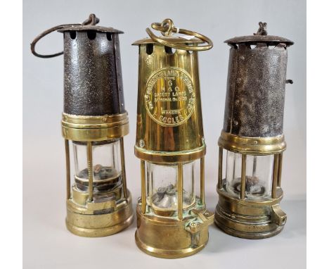 Three vintage brass Miner's lamps, one marked 'Protector Lamp Lighting Co Ltd Eccles'.  (3)  (B.P. 21% + VAT) 