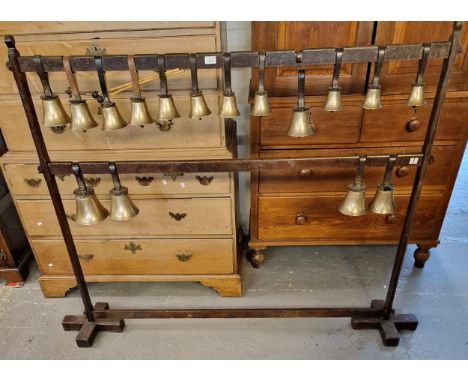 A set of bronze handbells with leather wrist straps, two strikers on a pegged oak display frame. (B.P. 21% + VAT) 