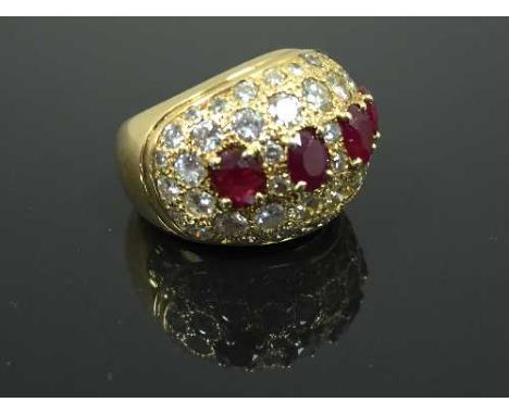 An 18ct gold Gentleman's diamond encrusted ruby ring, set with four mixed cut rubies, measuring 5.8mm x 4.8mm, each stone set