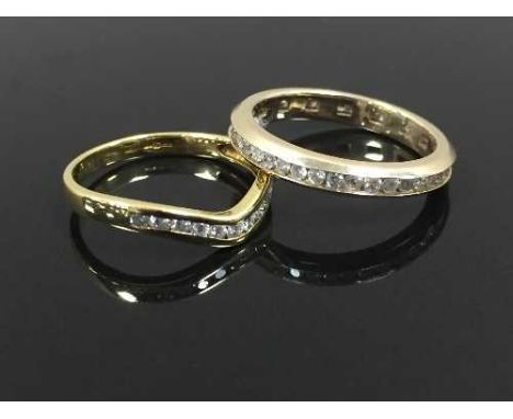 A diamond full eternity ring, size M/N, together with an 18ct gold wishbone diamond half eternity ring, size K/L. (2) CONDITI