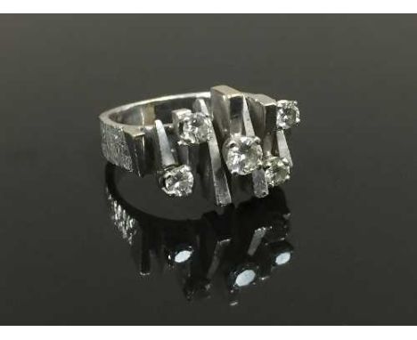 An 18ct white gold abstract ring set with diamonds, size K. CONDITION REPORT: Good condition, a heavy ring 8.2g.