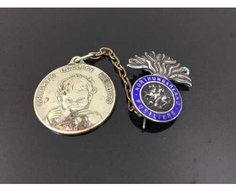A sterling silver and enamel Northumberland Fusiliers brooch, together with an advertising pendant 'Wrights Quality Biscuits'