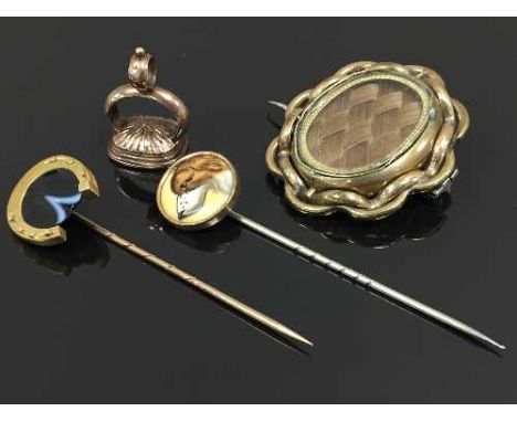 A nineteenth century stick pin with dog head terminal, together with a stick pin with horseshoe terminal, a nineteenth centur