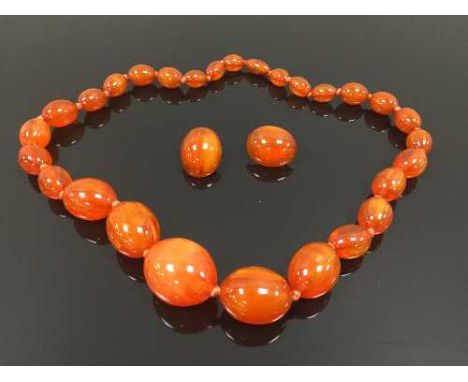 A vintage beaded necklace, together with matching pair of earrings. (3) CONDITION REPORT: Good condition, amber in colour.