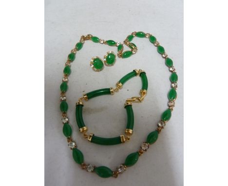 A yellow metal and Jade green hardstone sectional bracelet, the hardstone of curved cylindrical pieces capped in yellow metal