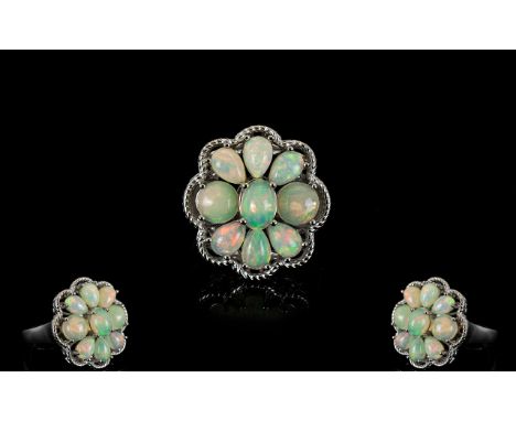 Opal Cluster Ring, comprising six pear cut and two round cut opal cabochons, closely set around an oval opal, totalling 3cts,