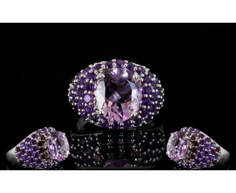 Amethyst and Rhodolite Garnet Dome Ring, an oval cut 4.5ct solitaire amethyst set above a domed ring, pave set with a single 