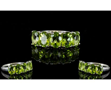 Peridot Five Stone Band Ring, five oval cut peridots totalling 4cts, set vertically as a band across the finger, in rhodium v