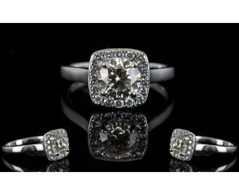 18ct White Gold Diamond Set Halo Dress Ring of Attractive Form and Top Quality. Full Hallmark for 18ct. The Central Round Bri