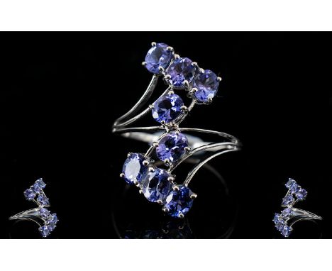 Tanzanite Crossover Ring, 3cts of oval cut tanzanites set in a 9ct white gold shank which divides into three strands at eithe