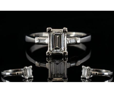 Platinum Emerald Cut Diamond Ring The central stone, set between two emerald cut diamond shoulders, fully hallmarked, ring si