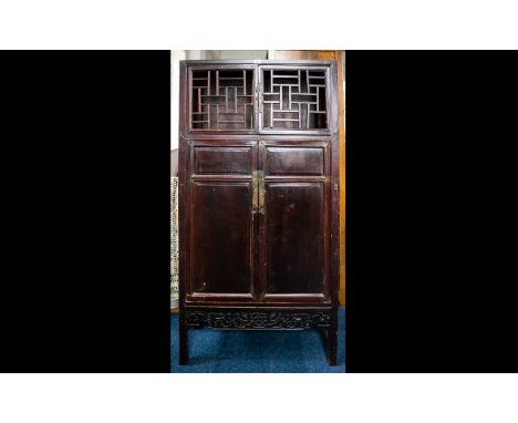 A Mid-Late 20th Century Oriental Style Cabinet Openwork lattice doors above panel doors with carved stretcher. In need of com