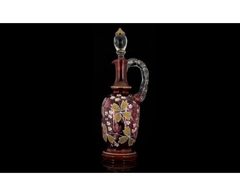 A Cranberry Glass Decanter Oil decanter of slim, elongated form with transparent frilled glass handle and gilt trimmed stoppe