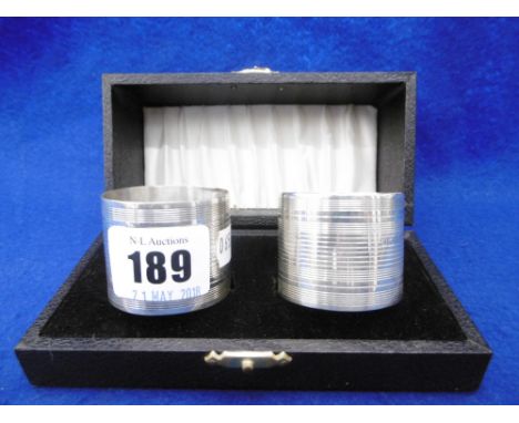 A PAIR OF ENGINE TURNED BOXED HALL MARKED SILVER NAPKIN RINGS