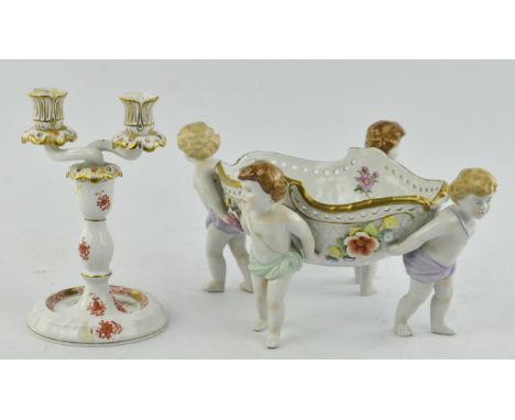 A Sitzendorf style porcelain style comport, modelled as four cherubs supporting an oval floral decorated basket, height 17cm,