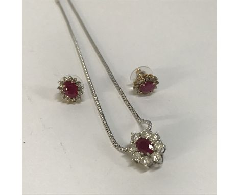 A 9ct gold ruby and diamond pendant with eight diamonds and a pair of earrings