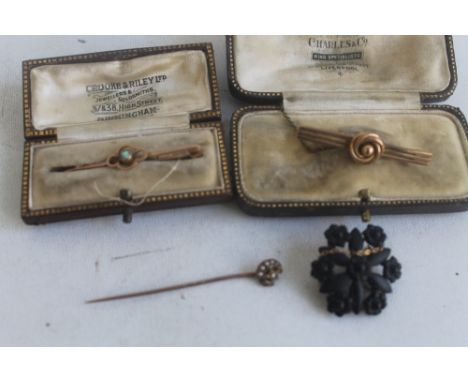 A SMALL COLLECTION OF 9 CT GOLD AND YELLOW METAL JEWELLERY consisting of three brooches and a stick pin